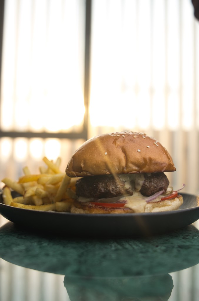 Signature burger and fries in warm, golden window light